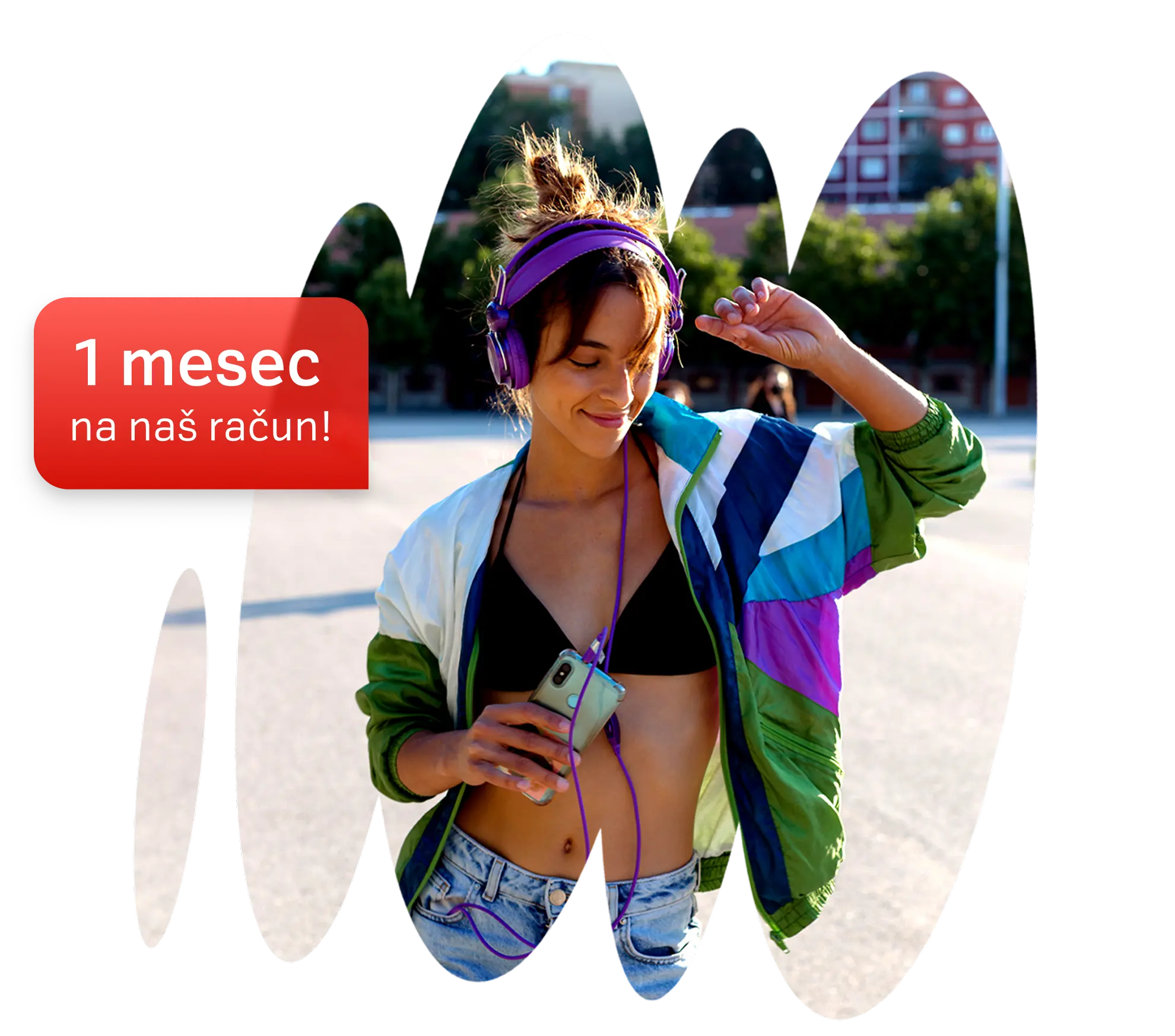Mlada ženska s slušalkami posluša glasbo Deezer in pleše na prostem. Promocijsko besedilo: 1 mesec na naš račun.